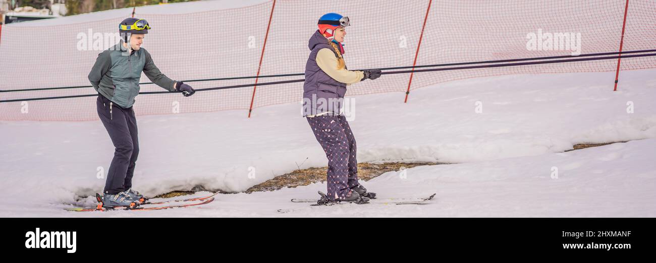 Woman learning to ski with instructor. Winter sport. Ski lesson in alpine school BANNER, LONG FORMAT Stock Photo