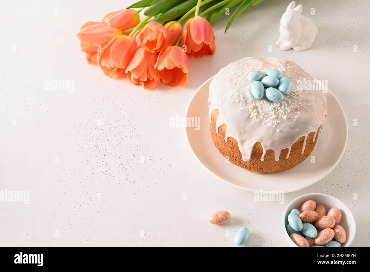 Composition with Easter cake, rabbit and chocolate eggs, spring tulips. Christian custom. Copy space. Festive morning. Stock Photo