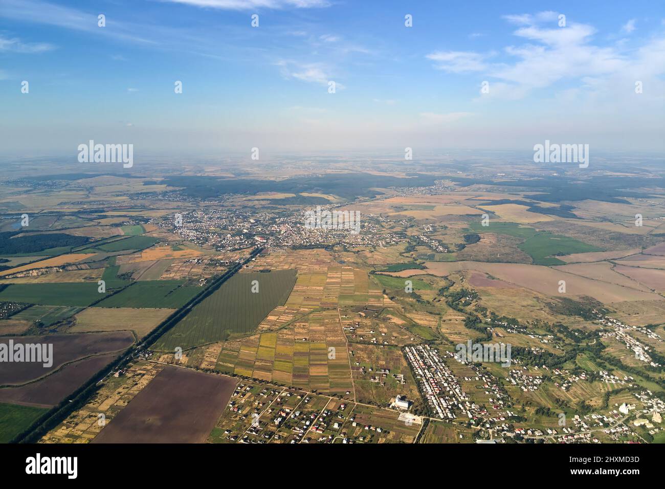 Aerial view of farm fields and distant scattered houses in rural area ...