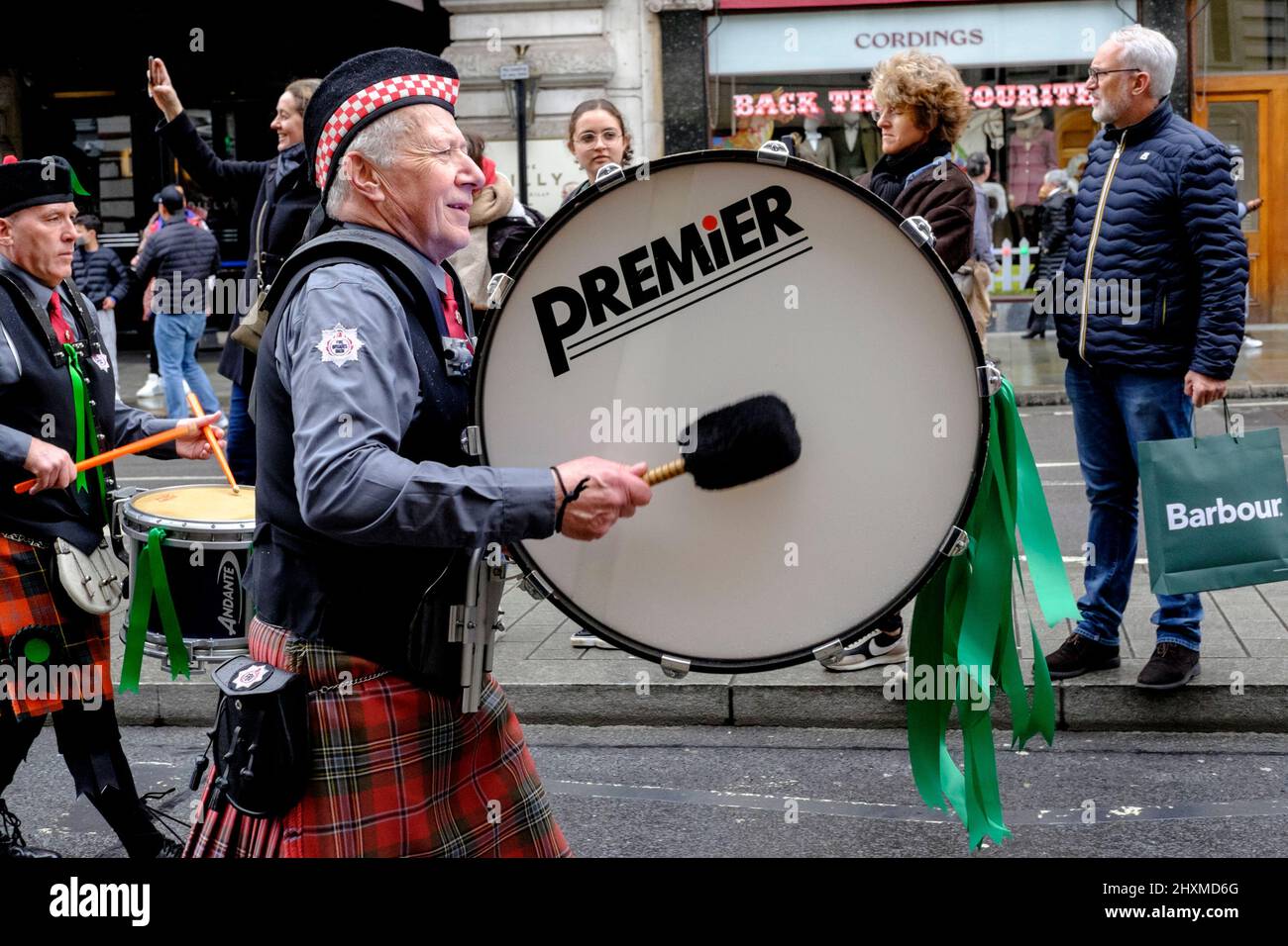 London, UK. 13th March 2022. The Fire Brigade Union Pipes and Drum band perform along the route of the St Patrick's Day Parade. The annual event returns to the capital after a two year hiatus due to the coronavirus pandemic. Stock Photo