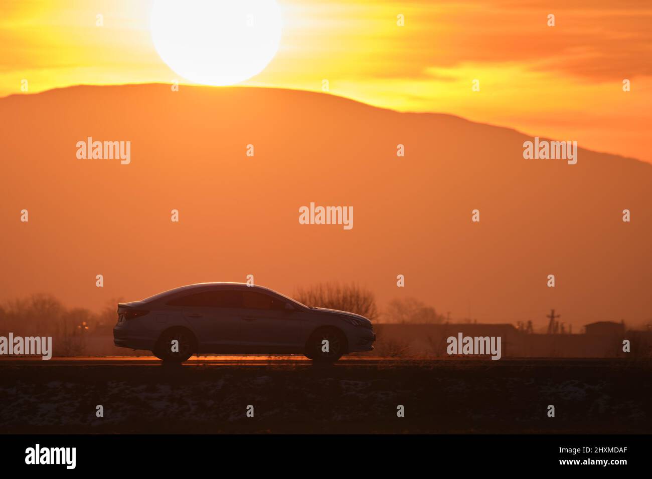 Car driving fast on intercity road at sunset. Highway traffic in