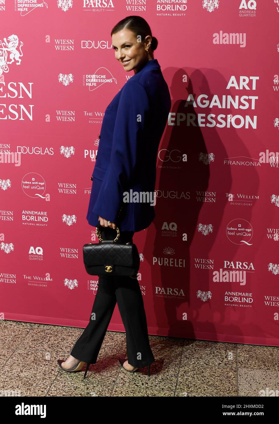 Duesseldorf, Germany. 13th Mar, 2022. Presenter Laura Wontorra joins the  "Art Against Depression" charity dinner. Here, singer and photographer  Adams will make 40 hand-signed photos of his work "Amy Winehouse, Laing on
