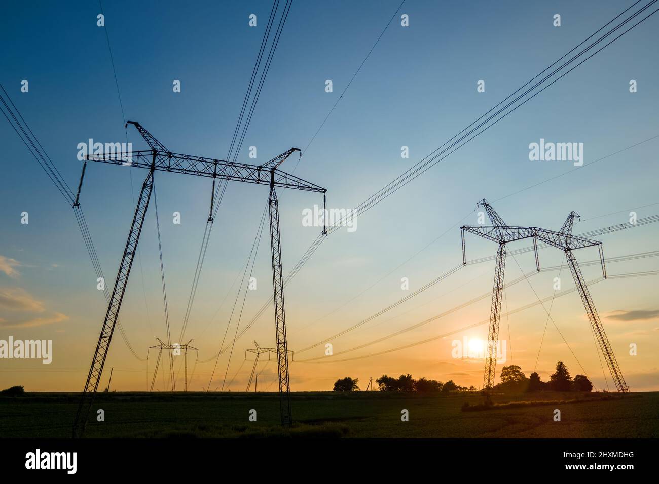 High voltage towers with electric power lines at sunset Stock Photo - Alamy