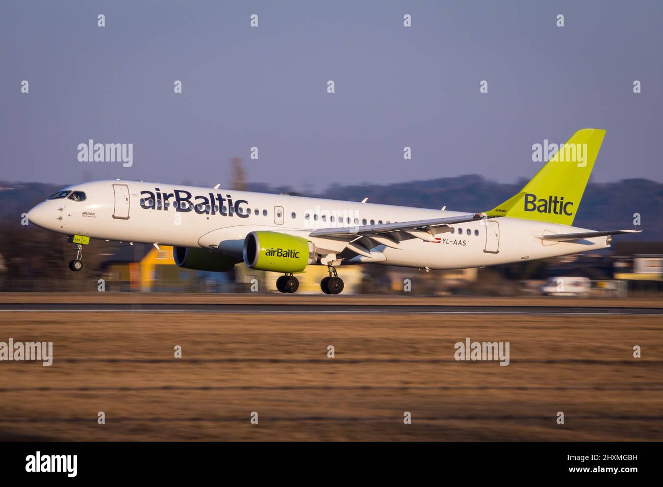 Air Baltic Airbus A220 landing at aerodrome Graz, Austria coming from Stuttgart in beautiful sun light Stock Photo