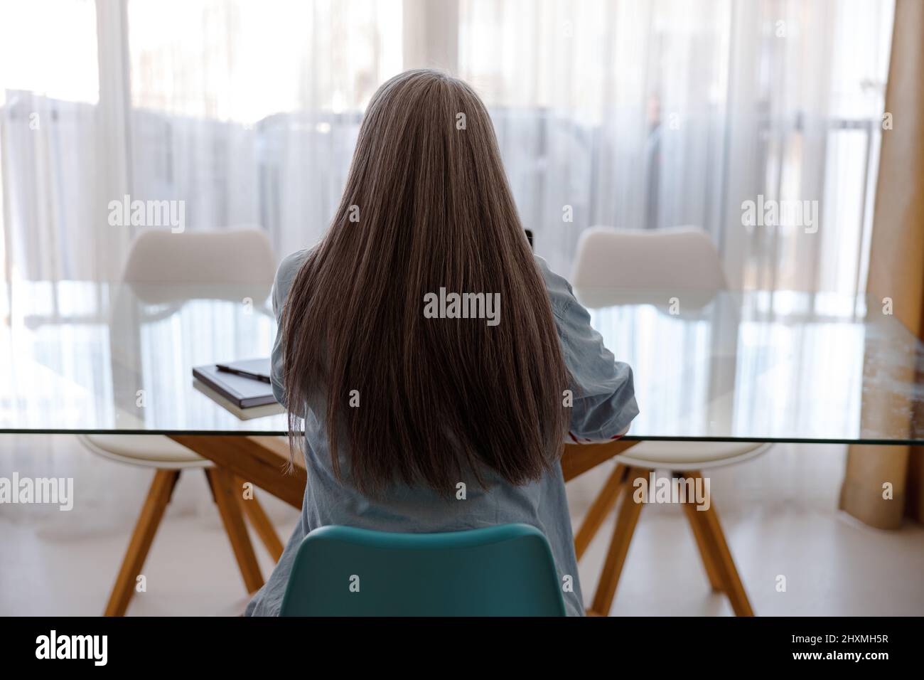 Woman sitting at the table in living room Stock Photo