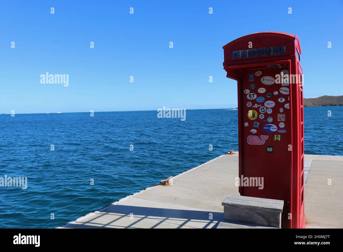 Red telepone box covered in stickers converted into a shower for sailors on jetty in Leverick Bay on Gorda Sound in the British Virgin Islands Stock Photo