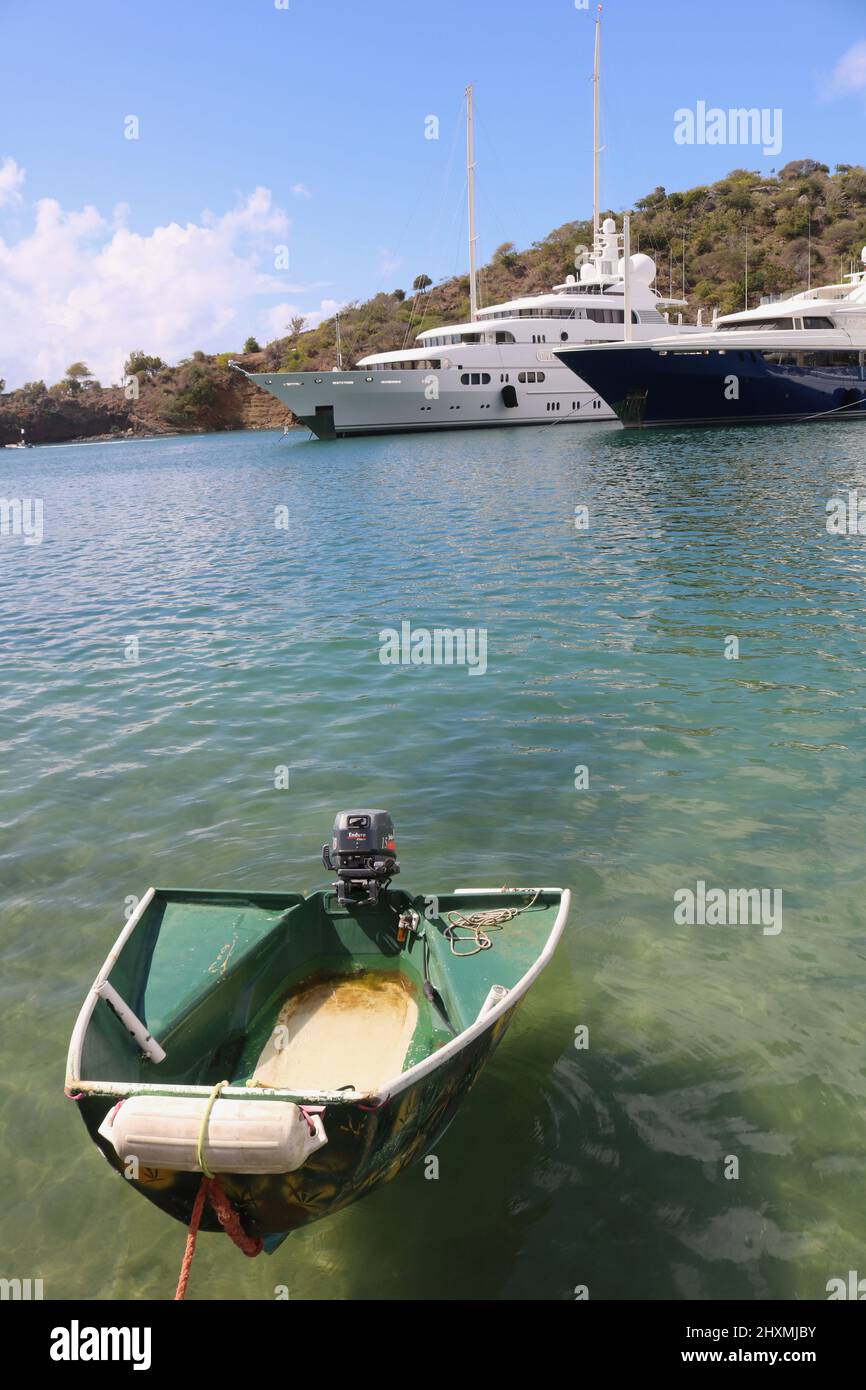 Contrasting luxury yachts with a simple little boat in English Harbour