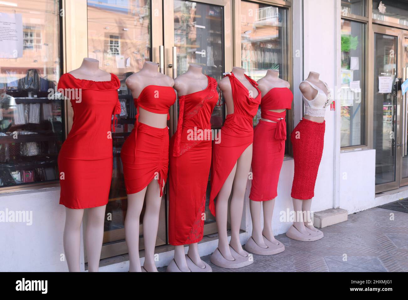 Six female mannequins wearing different red dresses outside a shop in St John's on Antigua and Barbuda Stock Photo
