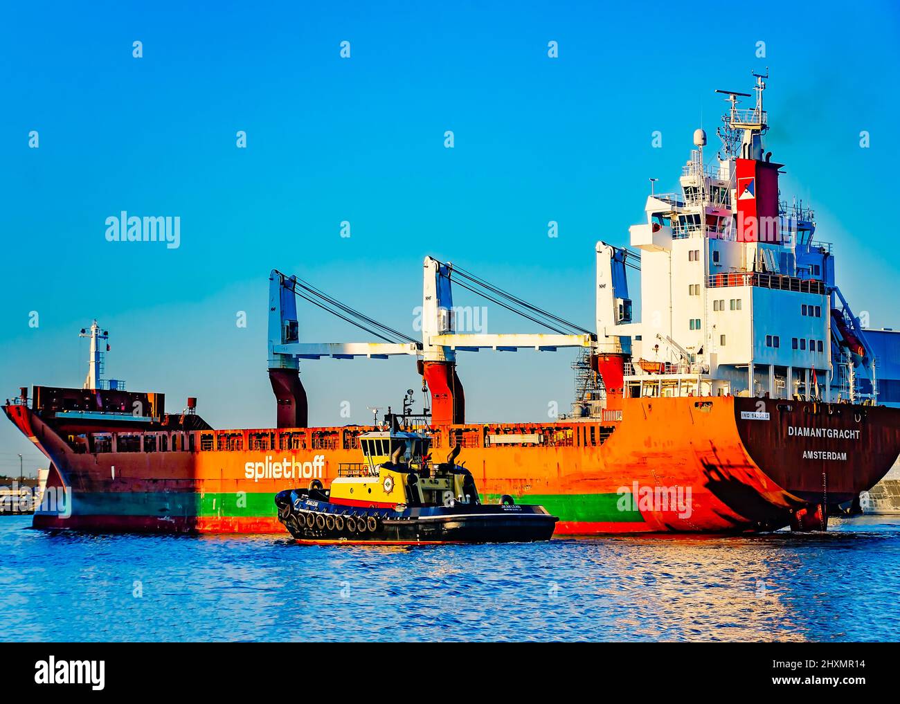 The J.K. McLean tugboat guides the Diamantgracht cargo ship into the Port of Mobile, March 10, 2022, in Mobile, Alabama. Stock Photo