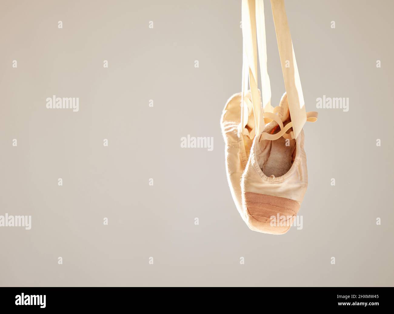 Ballet is only good when it is great. Shot of a pair on ballet shoes hanging in a dance studio. Stock Photo