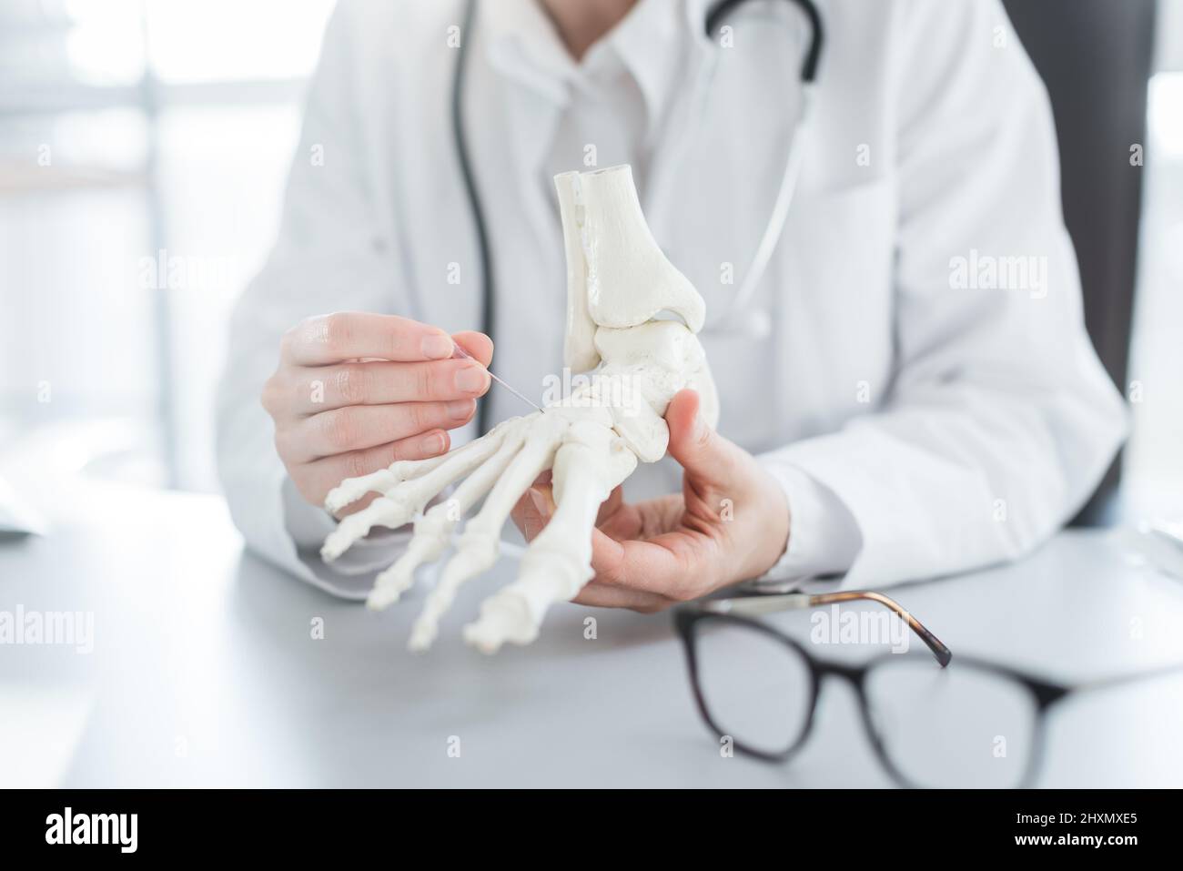 Doctor explaining operation to foot on bone model Stock Photo Alamy