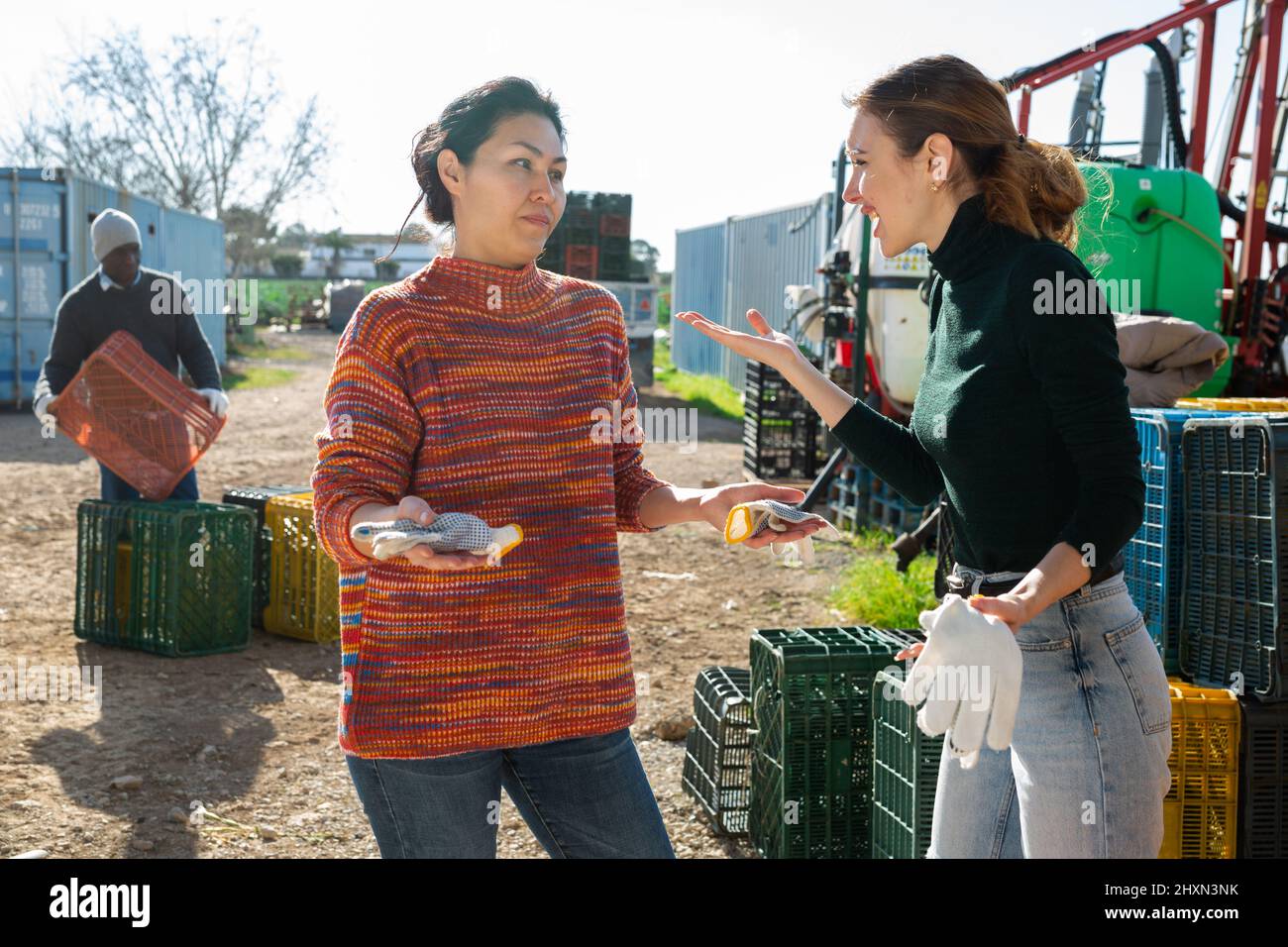 Women agriculturists quarreling outdoors Stock Photo
