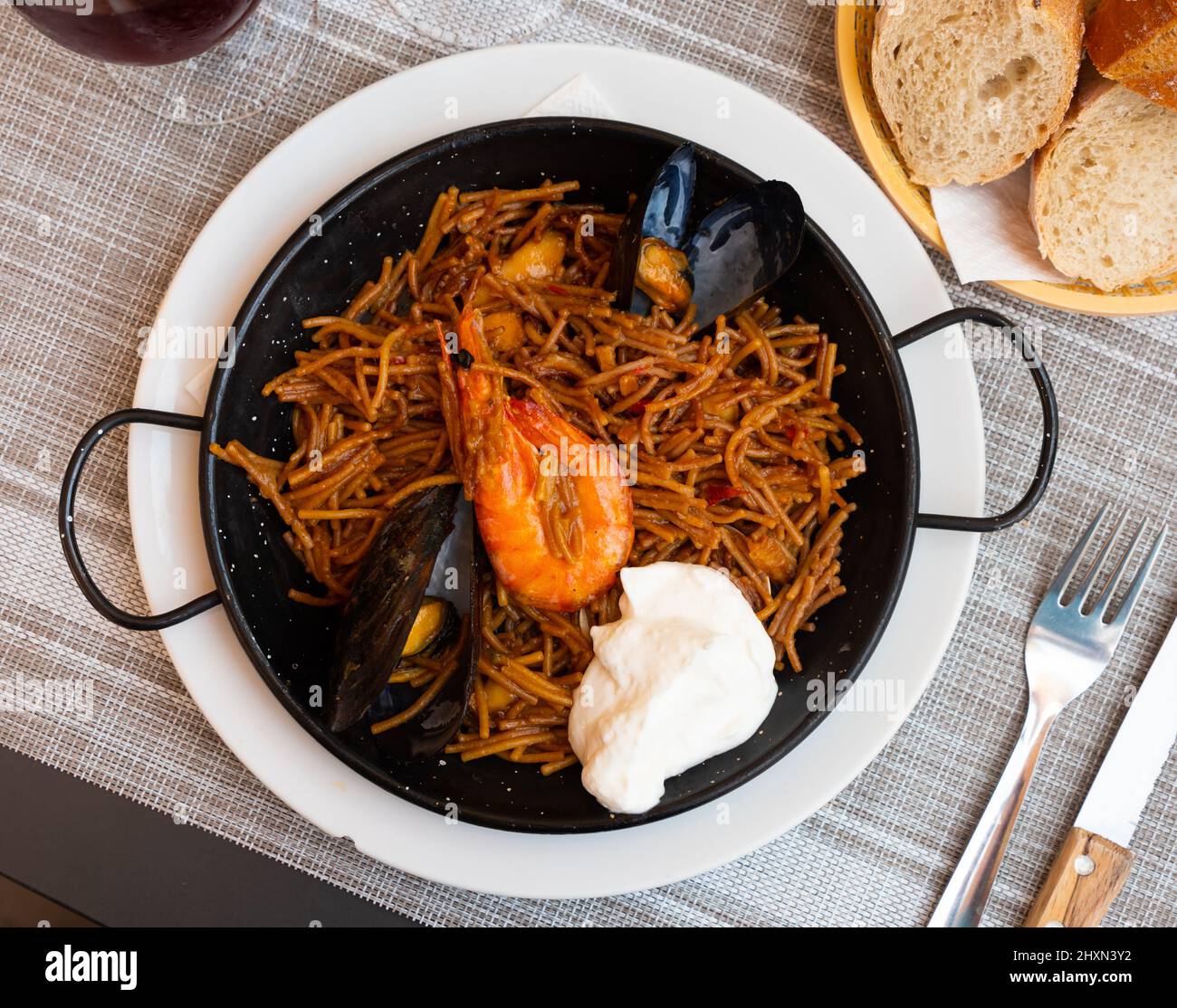 Spanish seafood fideua, noodle paella with aioli Stock Photo Alamy