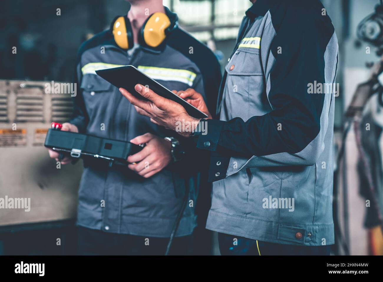 Group of factory job workers using adept machine equipment in a
