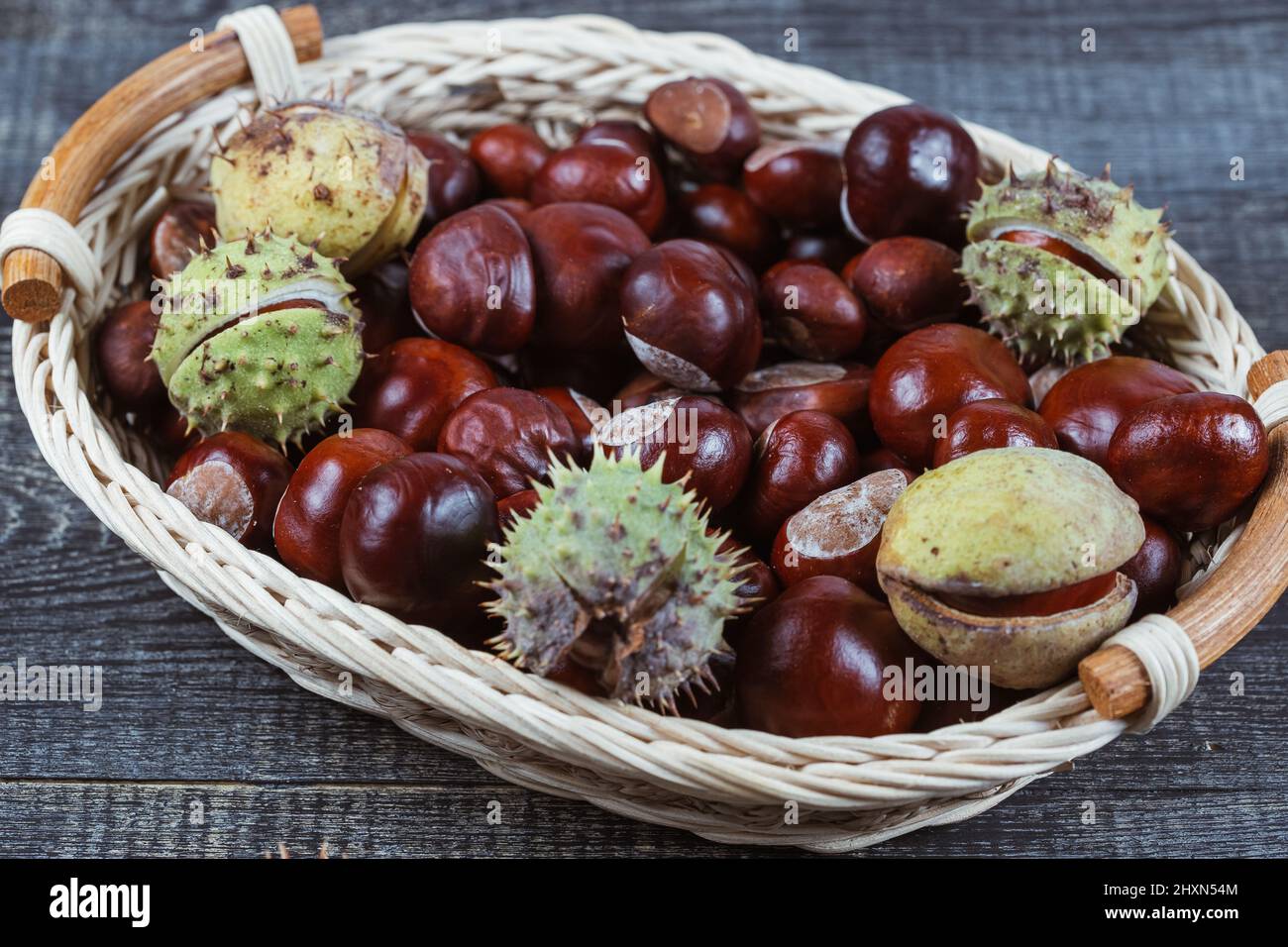 Close up view of Chestnuts in a basket on a wooden background Stock Photo