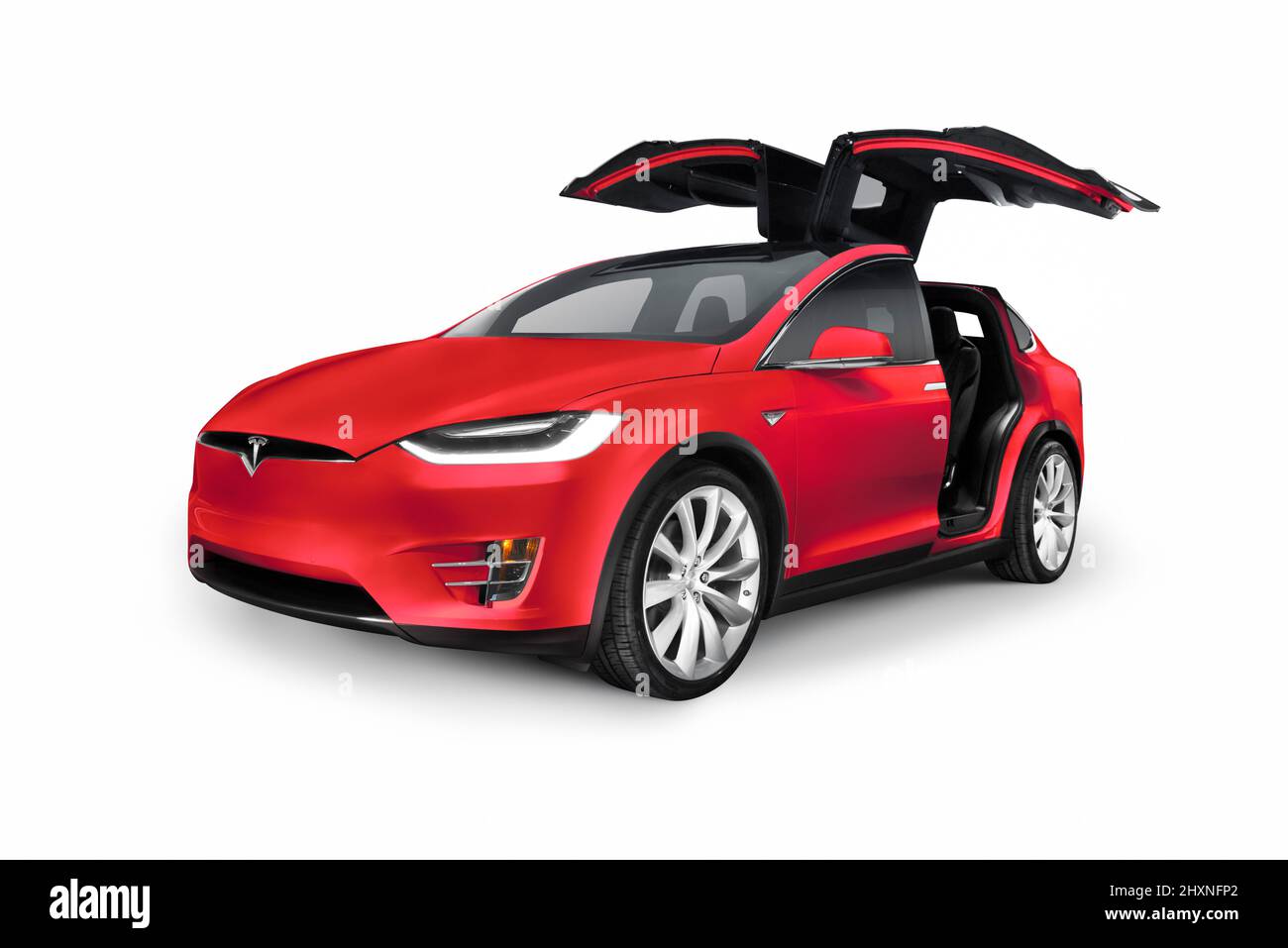 Red 2017 Tesla Model X luxury SUV electric car with open falcon wing doors isolated on white background Stock Photo