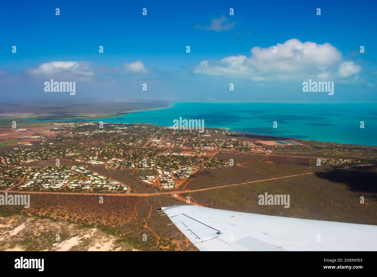 Aerial view of Broome, North Western Australia as the plane ascends for takeoff on sunny hot afternoon in the Summer Wet Season with the town below. Stock Photo