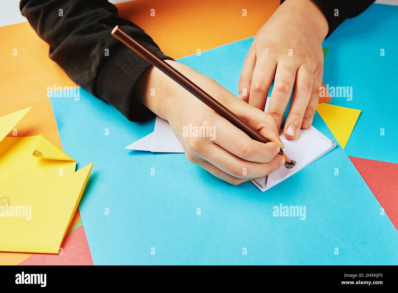 Boy hands making origami dog with colorful paper sheets, Child creative education Stock Photo