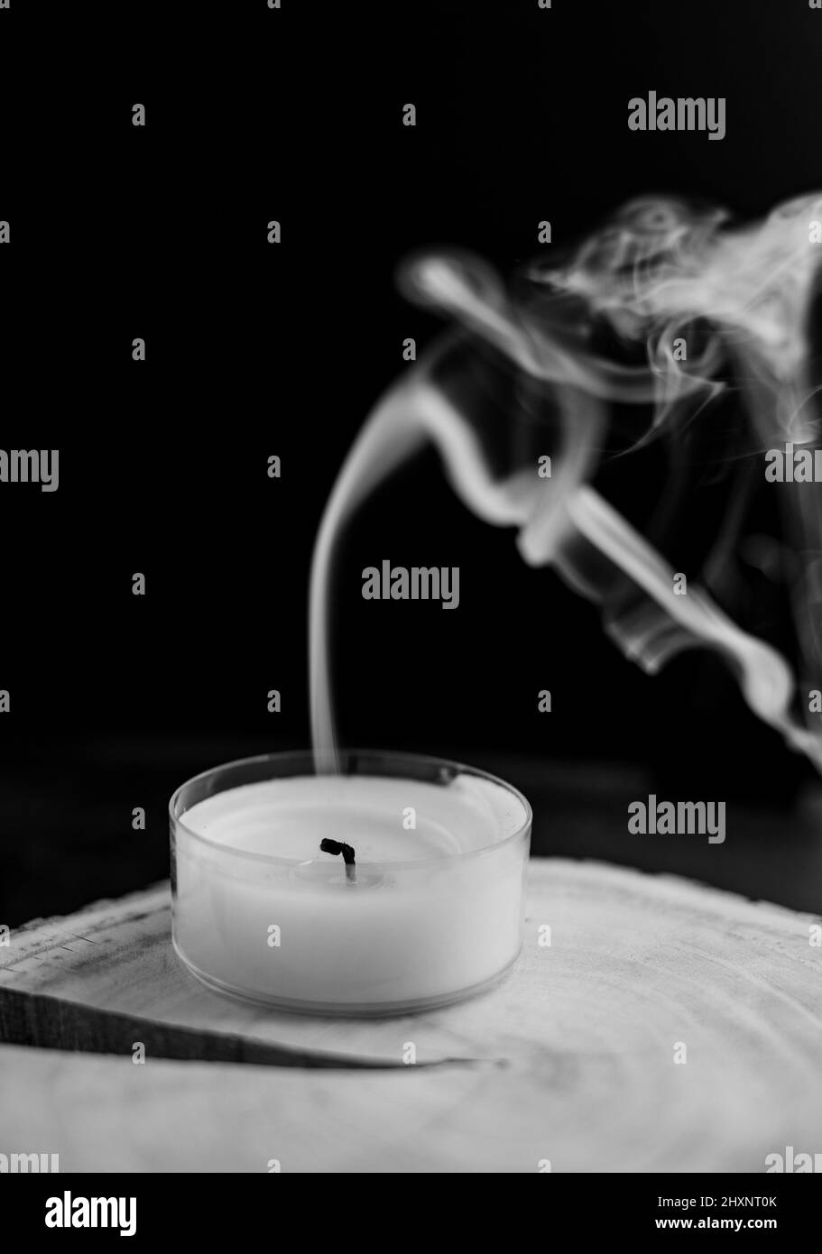 smoke of extinguished candle on a black background. sadness and longing. death Stock Photo