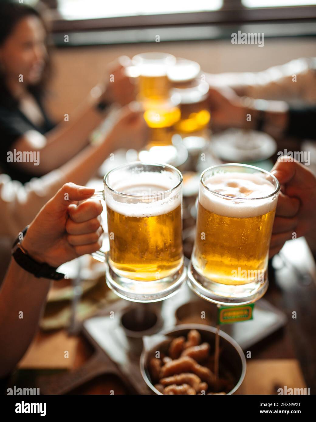 Happy multiracial friends toasting beer glasses at brewery pub Stock Photo  by engy91