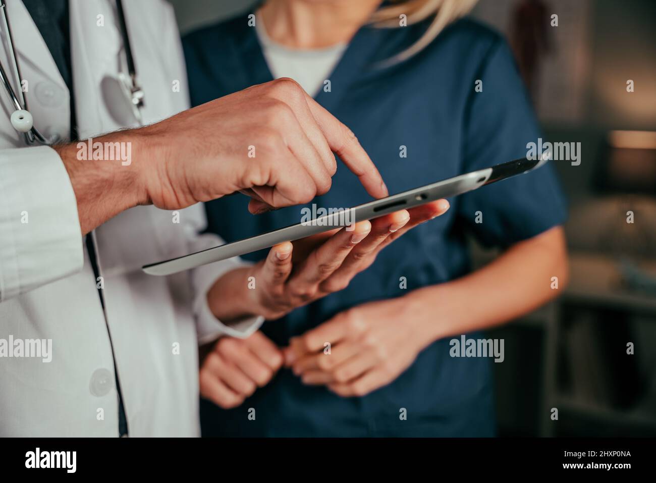 Close up male doctor typing on digital tablet  Stock Photo