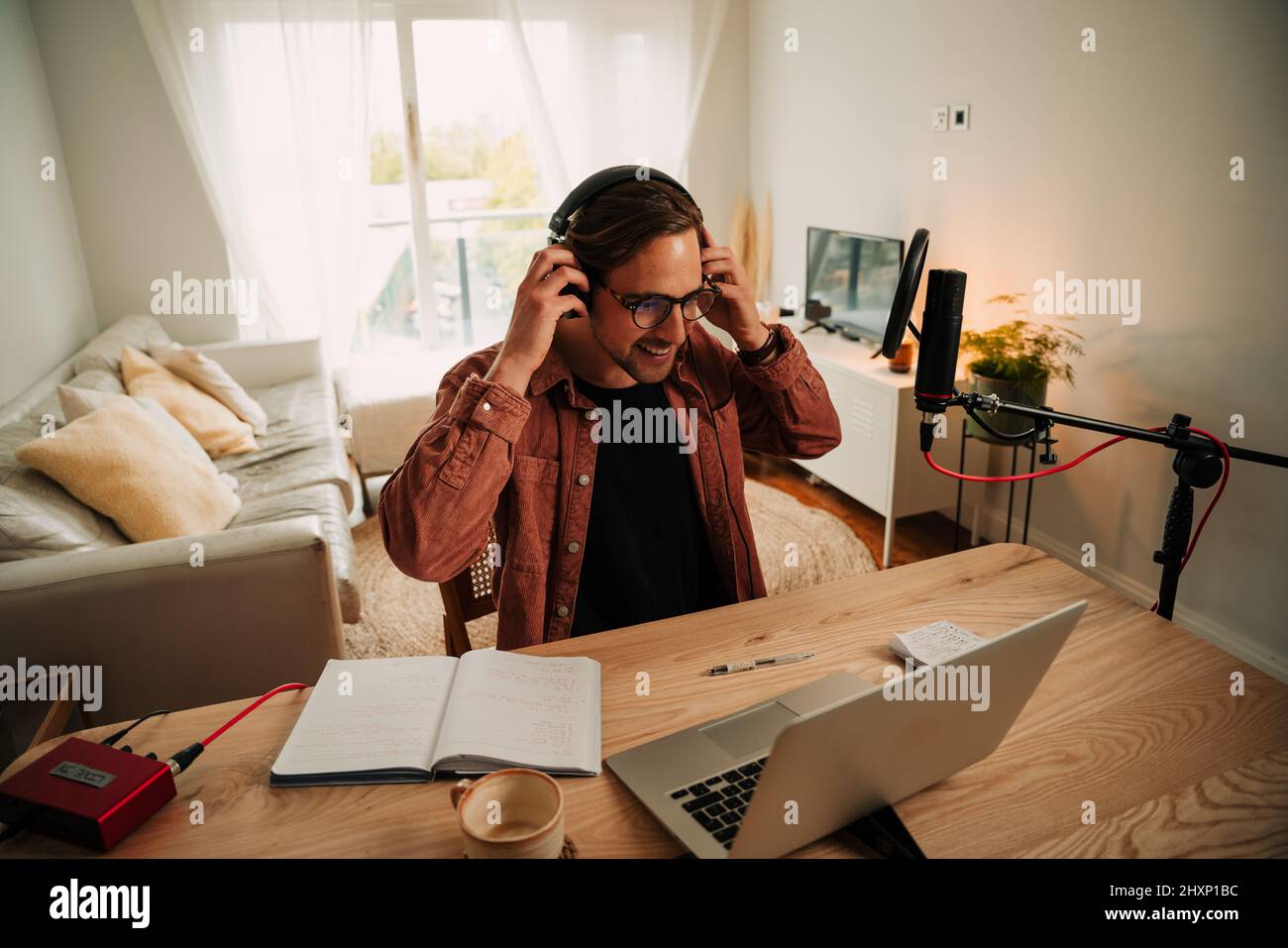 Caucasian male podcaster wearing head phones on live podcast with ...