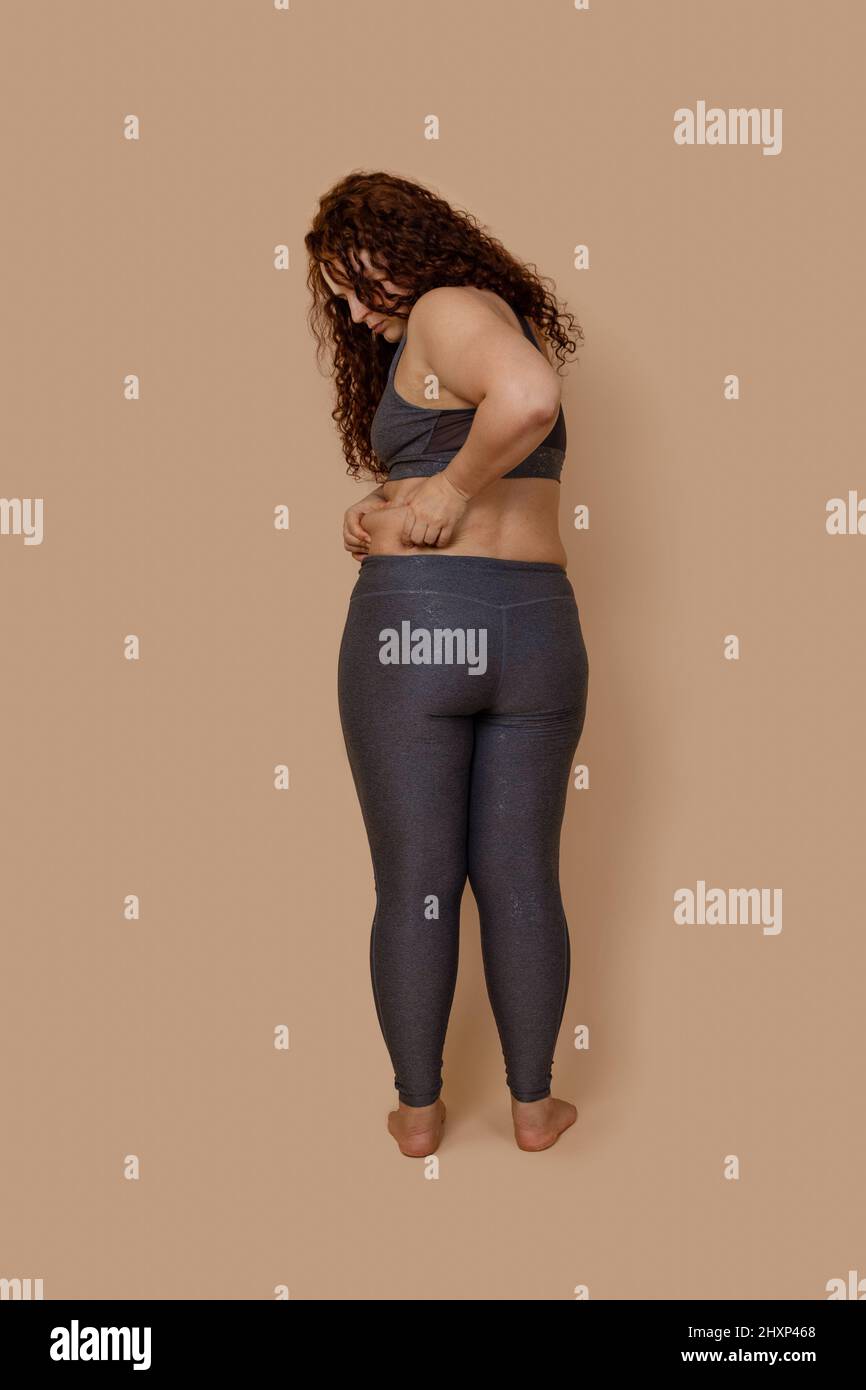 Vertical photo of rear barefoot concerned melancholic fat obese woman,  shove in leggings. Loosing motivation, body care Stock Photo - Alamy