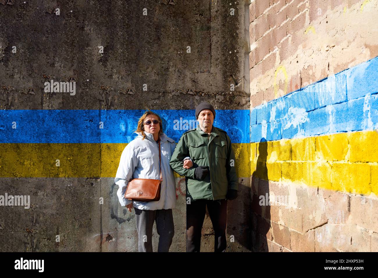 Older couple standing in front of a old wall Stock Photo