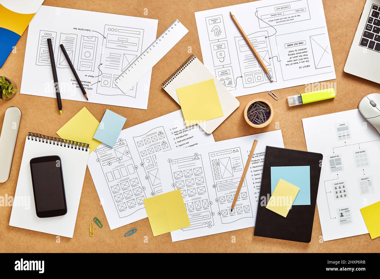 Top view image of web product designers workspace with many website wireframe sketches and sitemap. Stock Photo