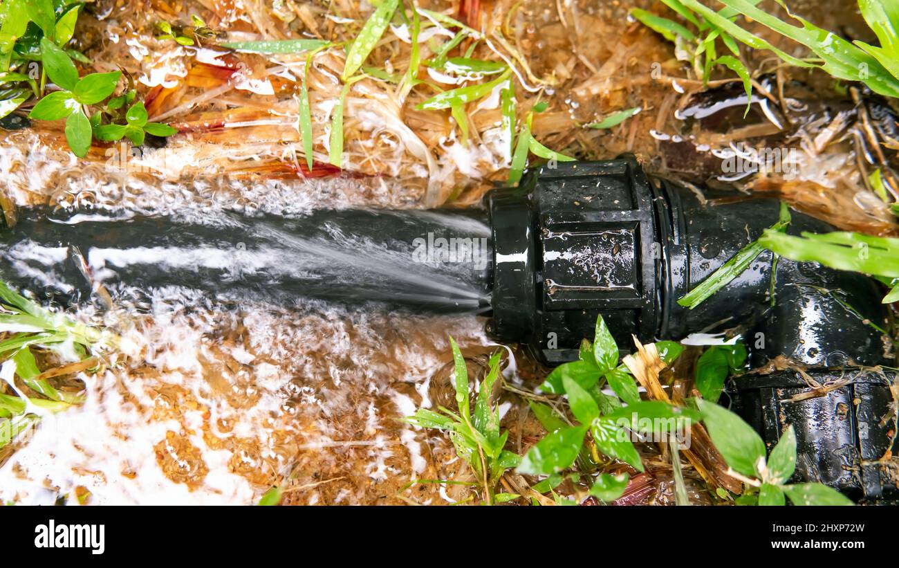 Broken water pipe line . Selective focus on the pipe and water flowing