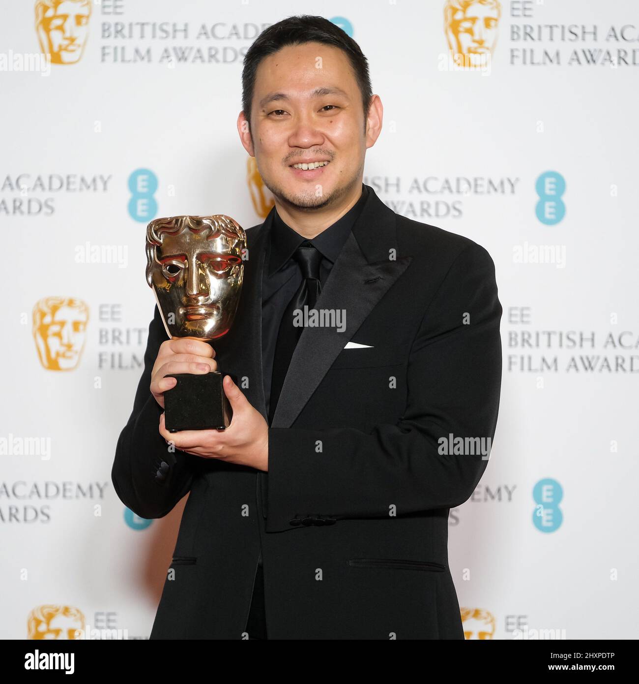 London, UK. 13th Mar, 2022. Ryusuke Hamaguchi poses with his Film Not in the English Language Award in the winners press room for the EE British Academy Film Awards on Monday, Mar. 14, 2022 at The Royal Albert Hall . Picture by Julie Edwards/Alamy Live News Stock Photo