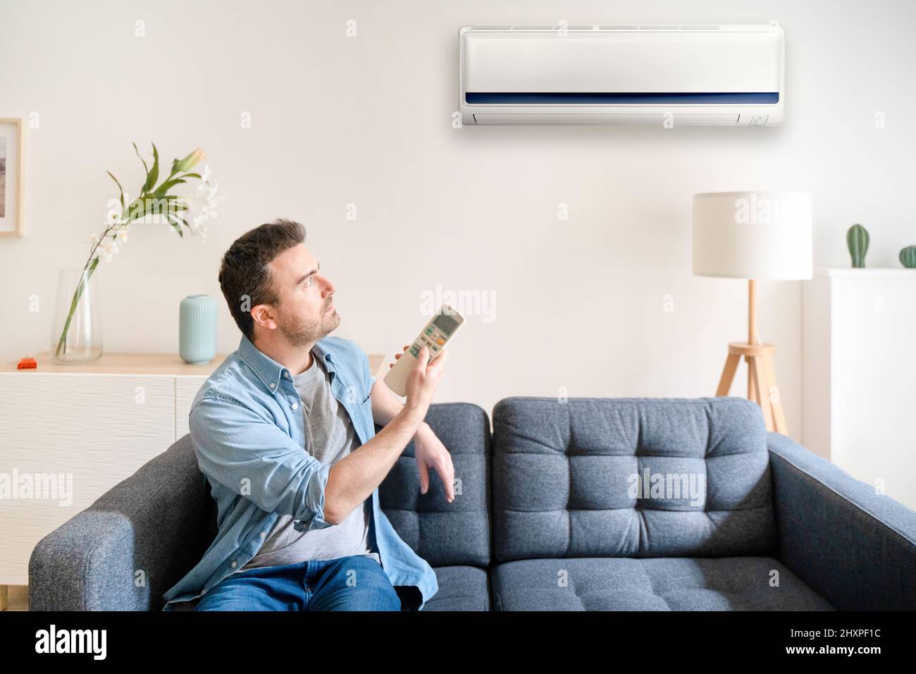 One man adjusting the air conditioner temperature using remote control