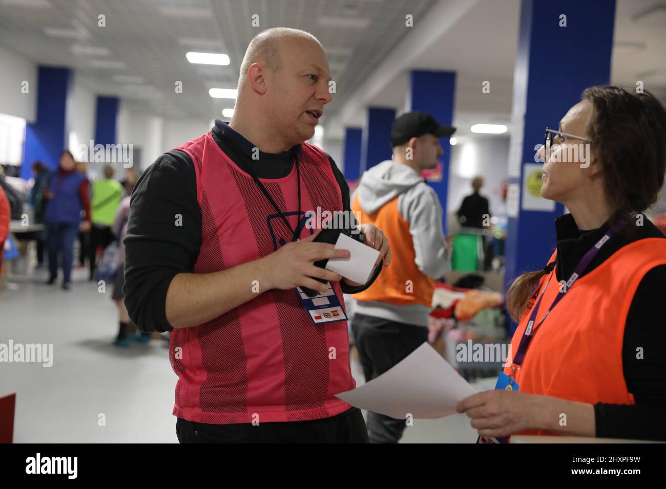 KRAKOW, POLAND - MARCH 9, 2022: Ukrainian refugees at the Suche Stawy (football club Hutnik Krakow Arena) in Cracow o/p volunteer Stock Photo