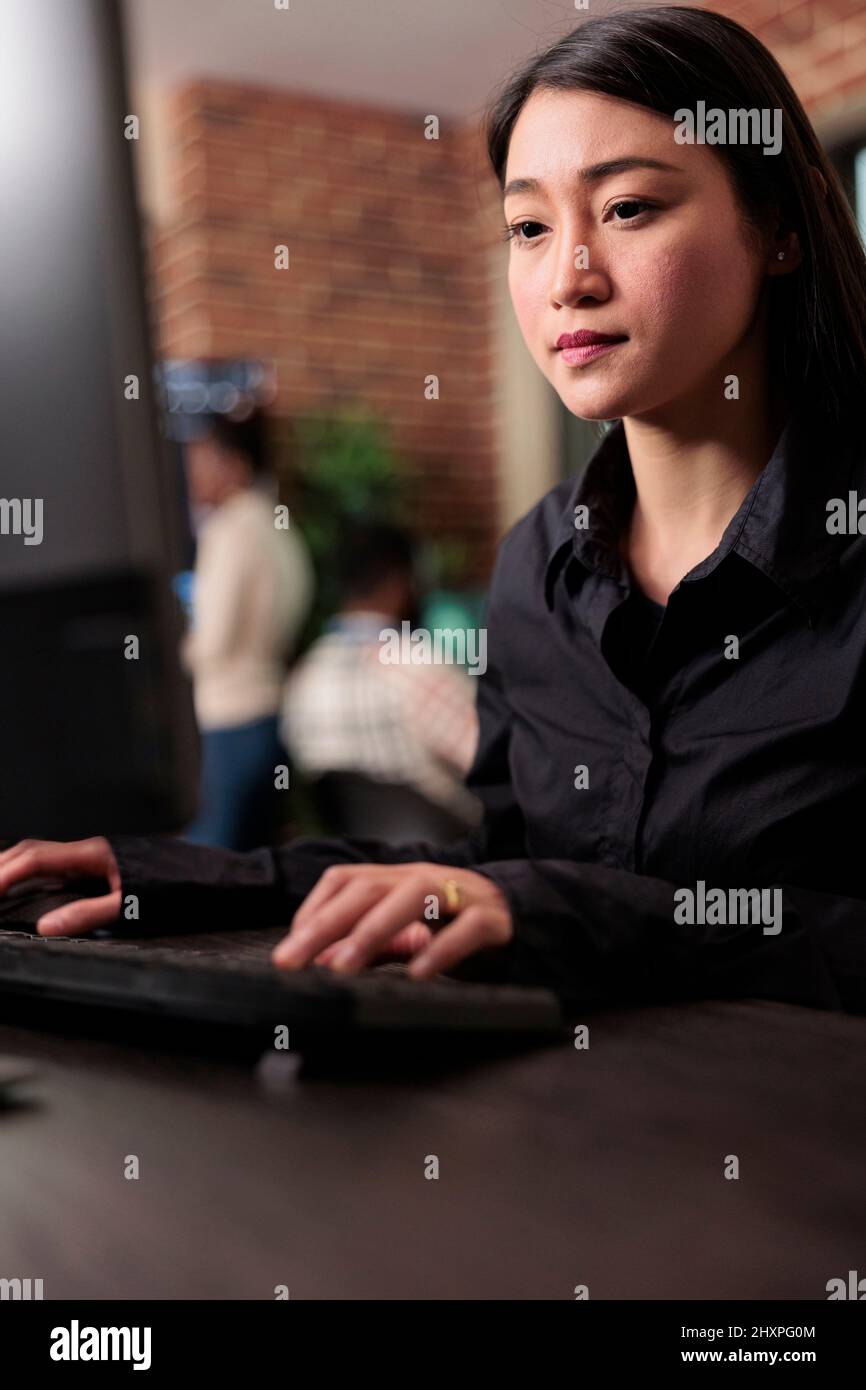 Asian system administrator upgrading firewall system in order to maintain security stability. Application developer encrypting cloud storage database by updating network algorithm. Stock Photo