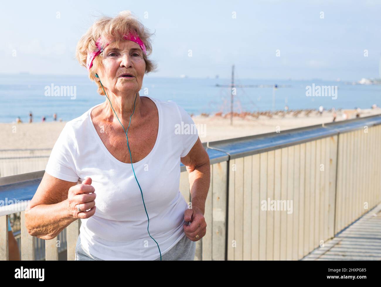 Old lady running beside beach Stock Photo