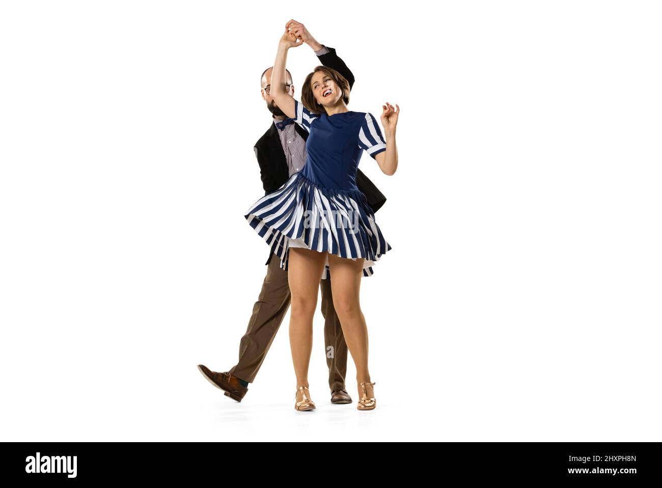 Happy young man and woman in vintage retro style outfits dancing lindy hop dance isolated on white background. Timeless traditions, 60s, 70s fashion Stock Photo