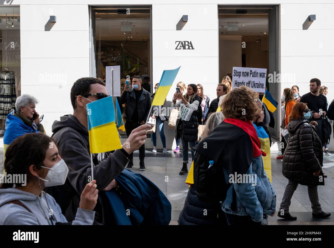 Madrid, Spain. 13th Mar, 2022. Pro-Ukraine protestors walk past the Spanish  multinational clothing design retail company by Inditex, Zara, as they take  part in a rally again the Russian invasion of Ukraine. (