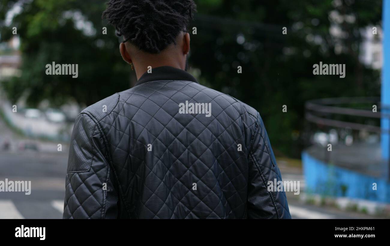 One young man walking outside in urban street person walks forward ...