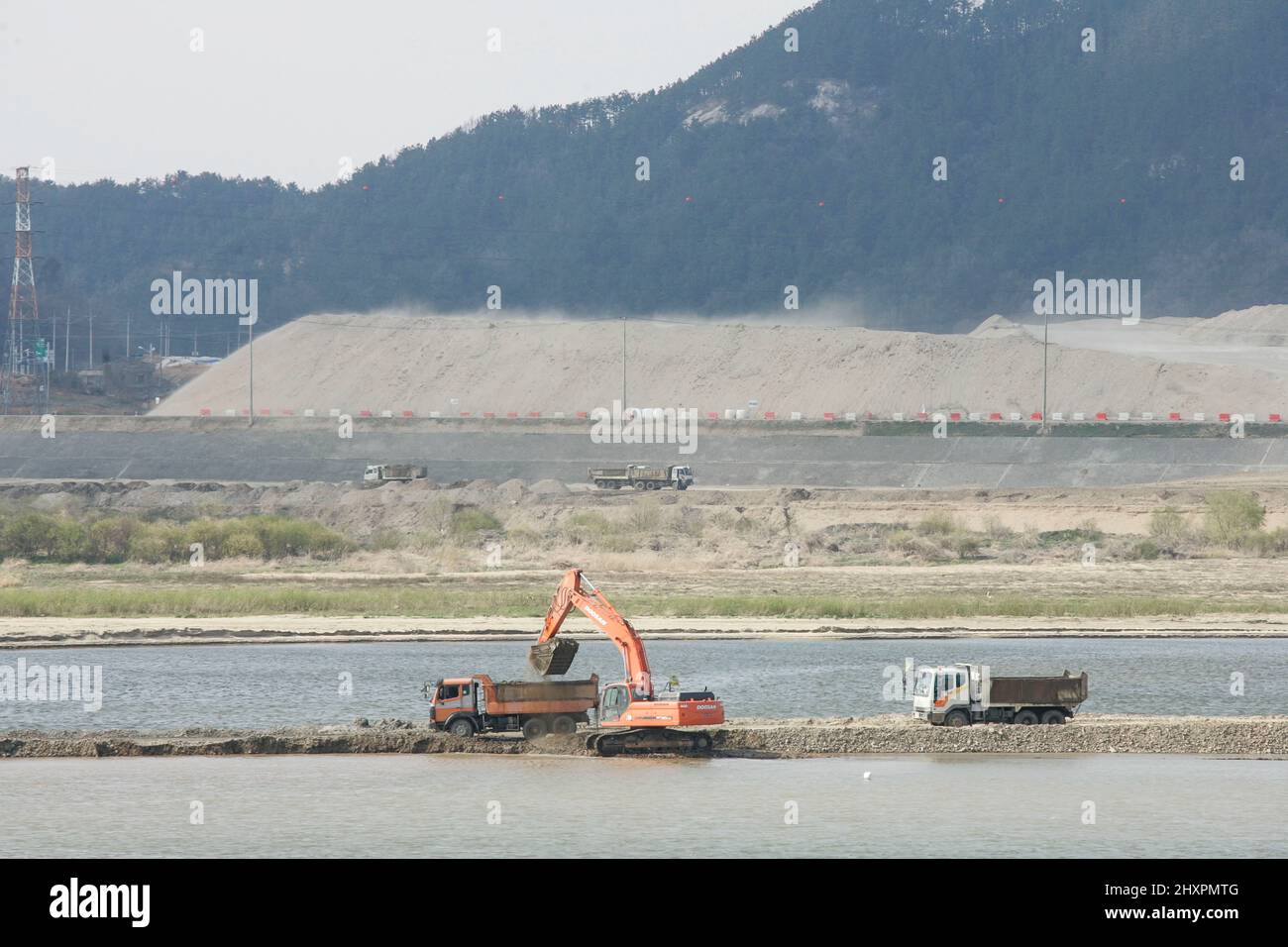 March 14, 2022-Seoul, South Korea-A Construction machines destroyed wetland in Gongju, South Korea. A Contemporary climate change includes both global warming and its impacts on Earth's weather patterns. There have been previous periods of climate change, but the current changes are distinctly more rapid and not due to natural causes. Instead, they are caused by the emission of greenhouse gases, mostly carbon dioxide (CO2) and methane. Burning fossil fuels for energy use creates most of these emissions. Agriculture, steelmaking, cement production, and forest loss are additional sources. Greenh Stock Photo