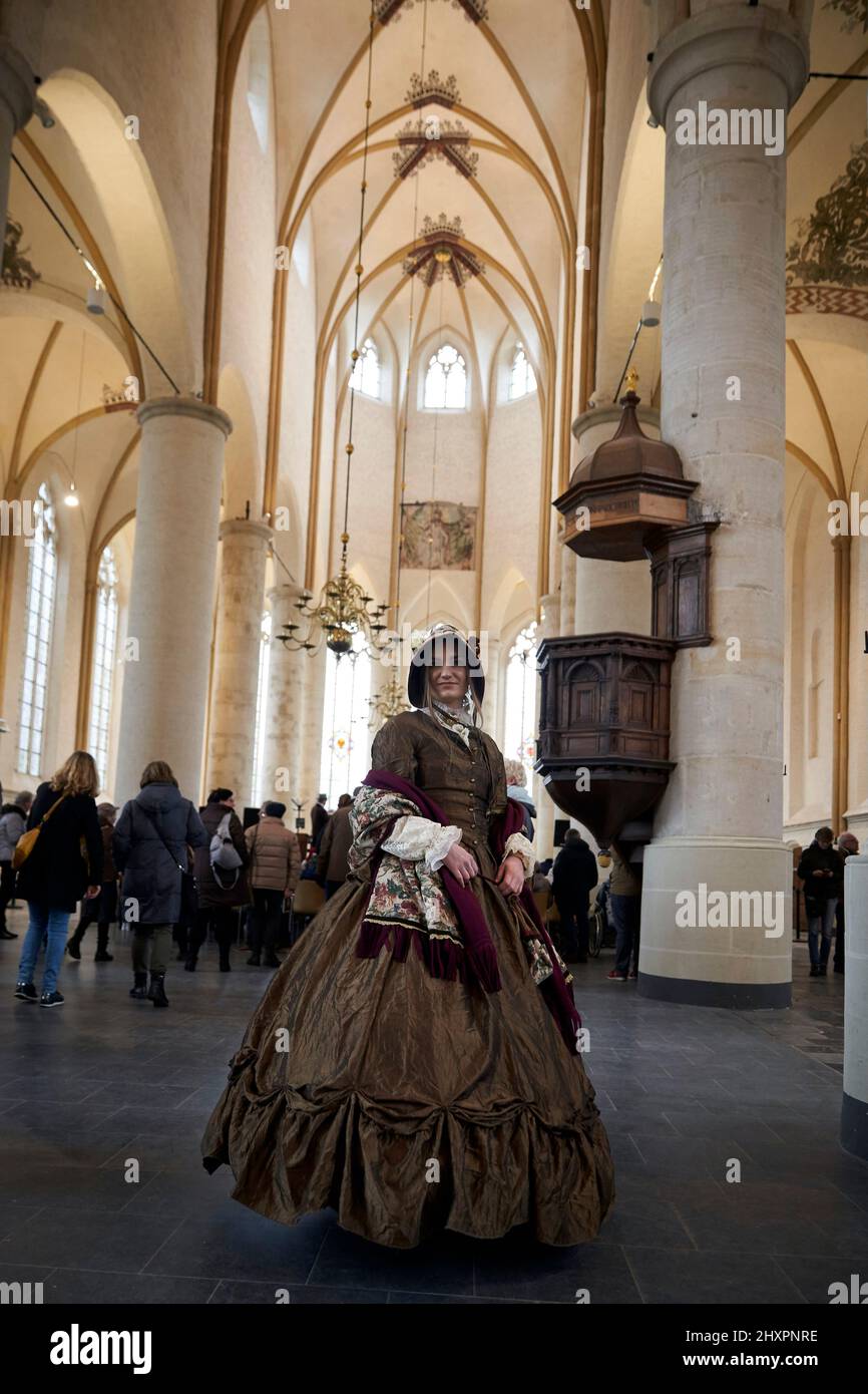 A woman in period costume inside Deventer church Stock Photo