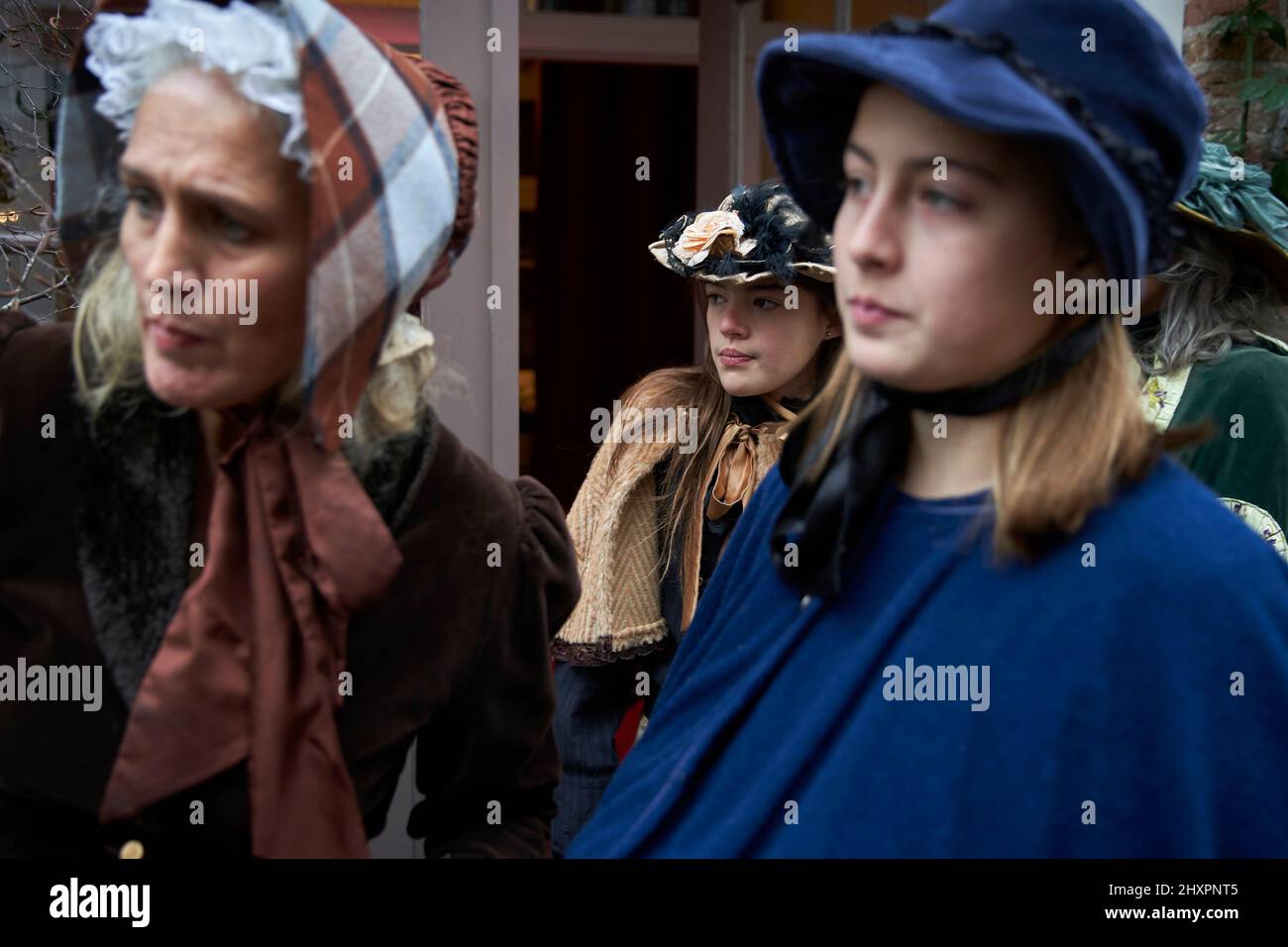 Young people from a family come out of their house dressed in period costumes Stock Photo