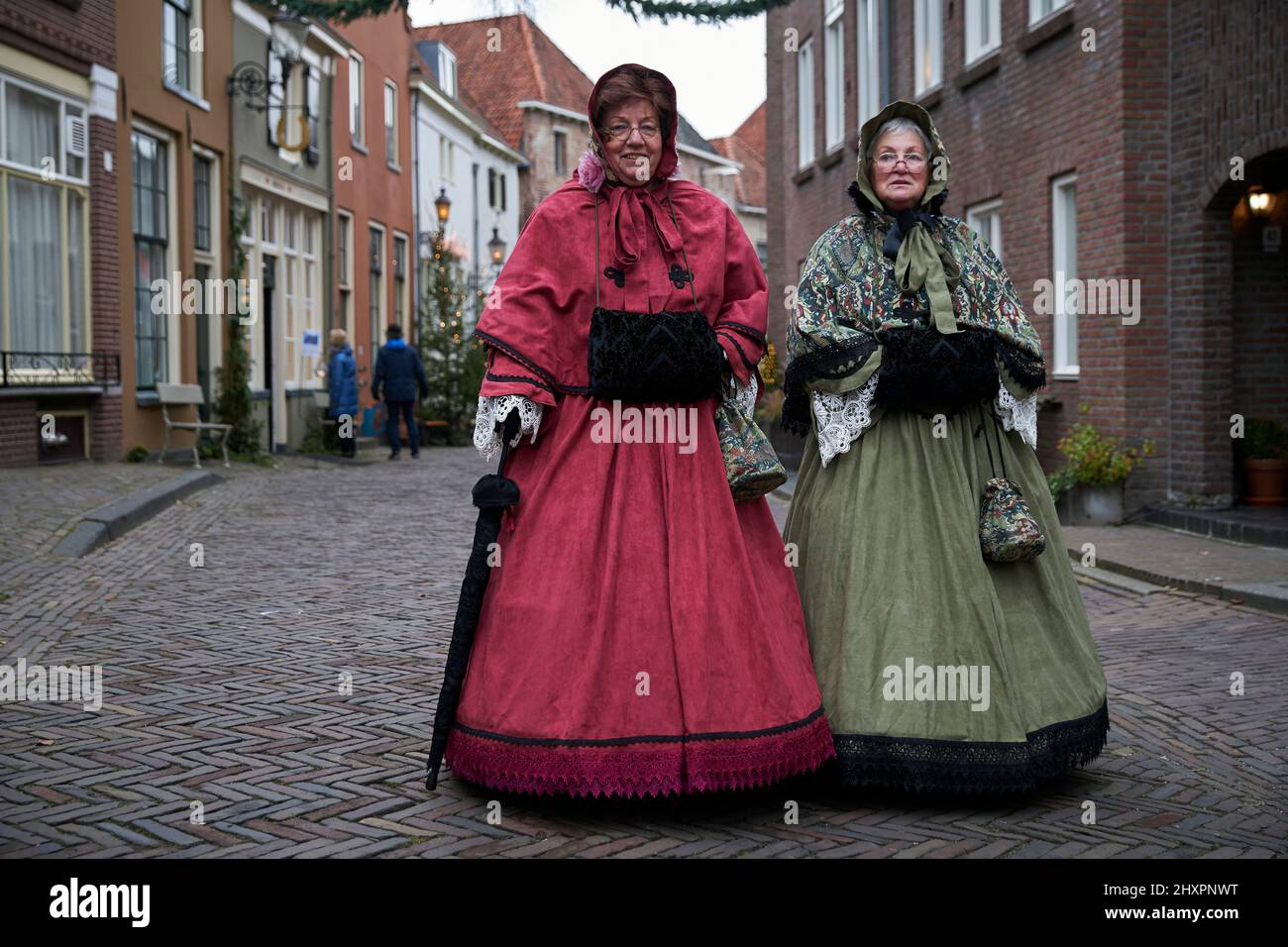 Two ladies stroll through the streets of Deventer dressed in period costume Stock Photo