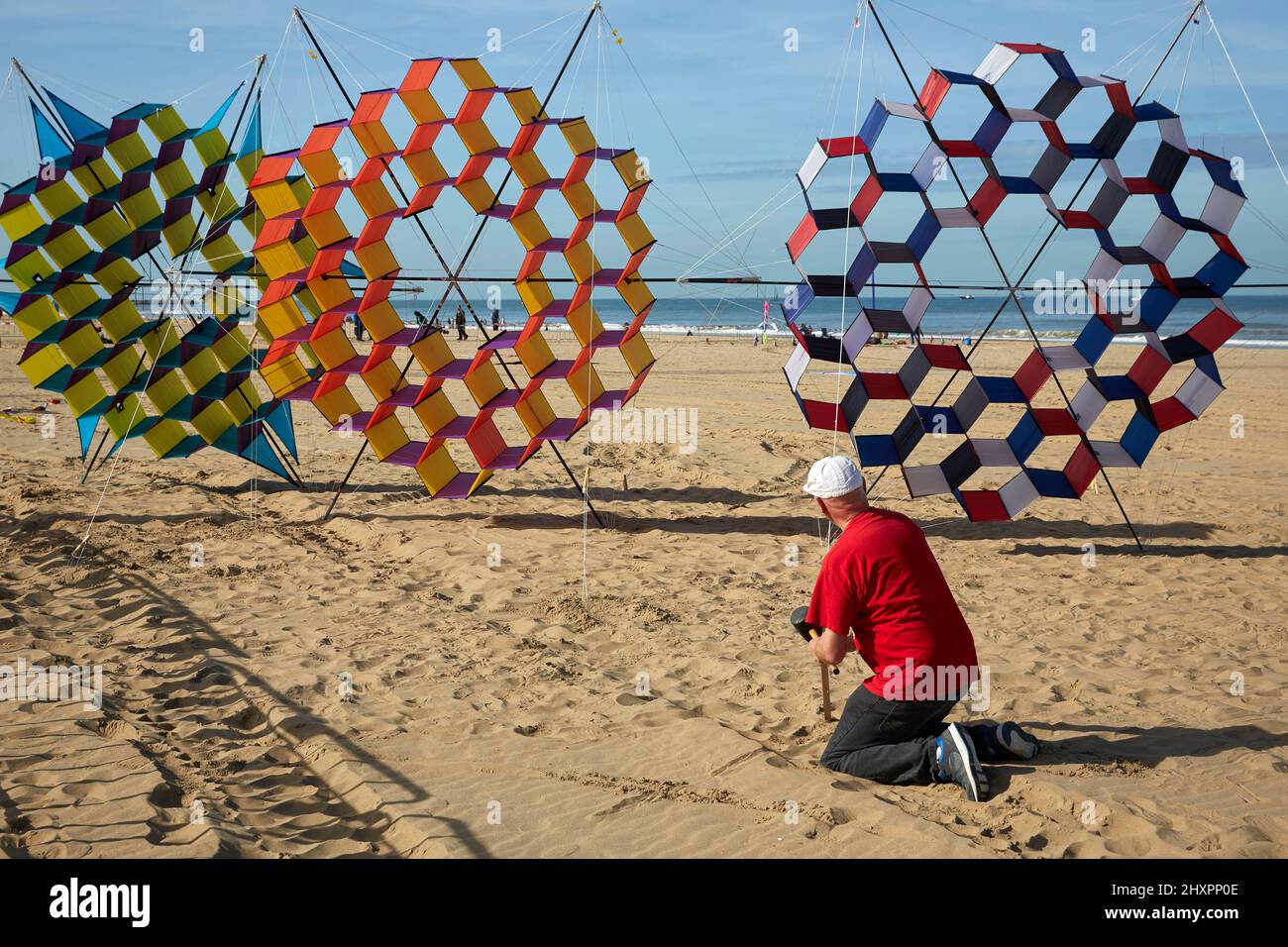 A participant holds their kites to the ground for later use during the exhibition Stock Photo
