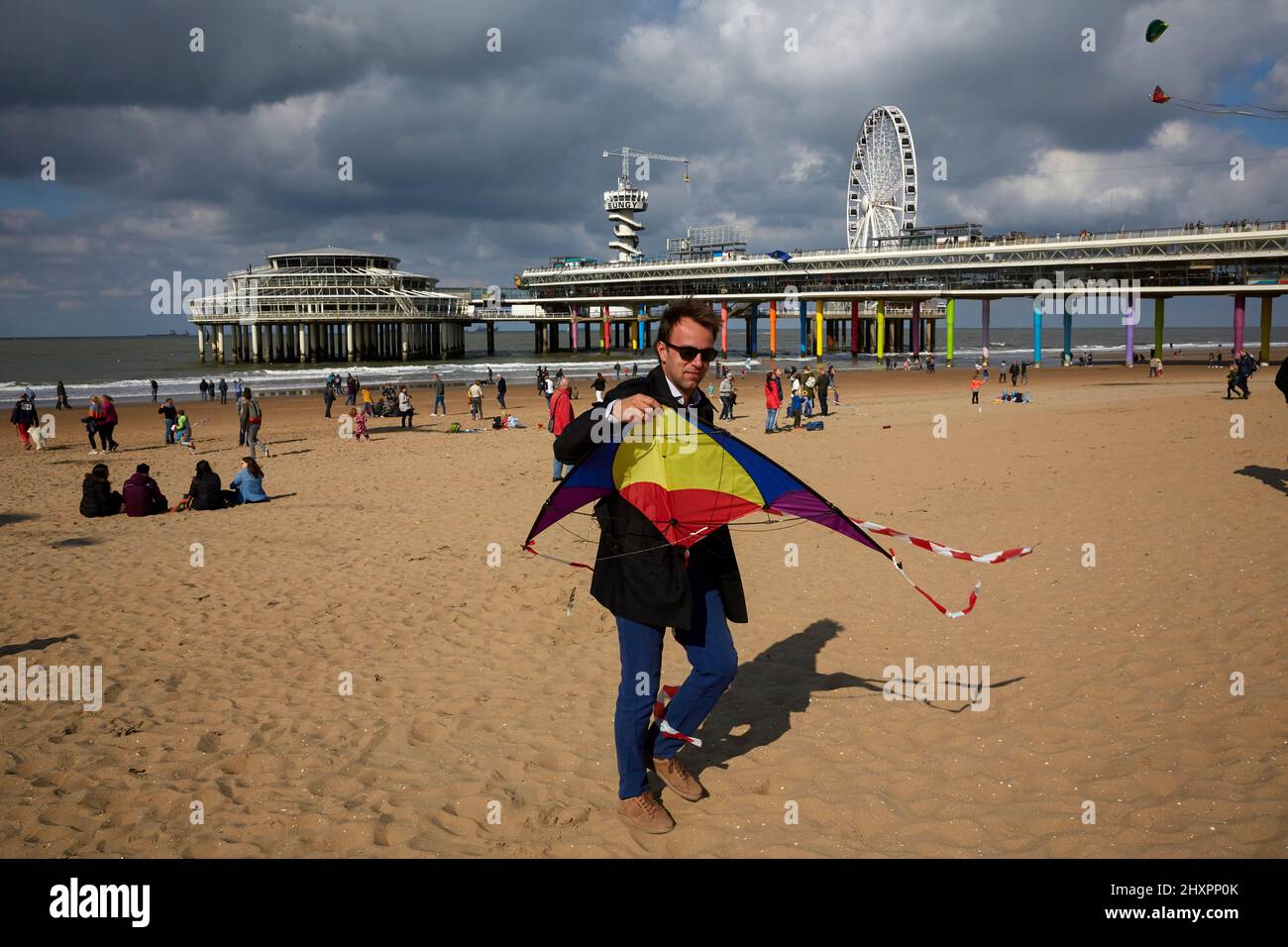 An assistant to the event participates with his small kite Stock Photo