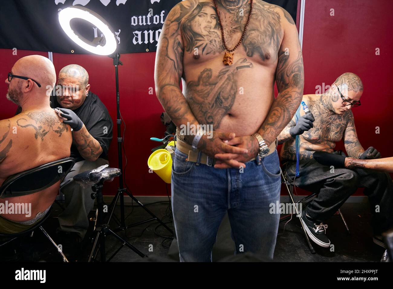 The tattooists work on their designs at the Bakes-Tattoo stand in Amsterdam Stock Photo