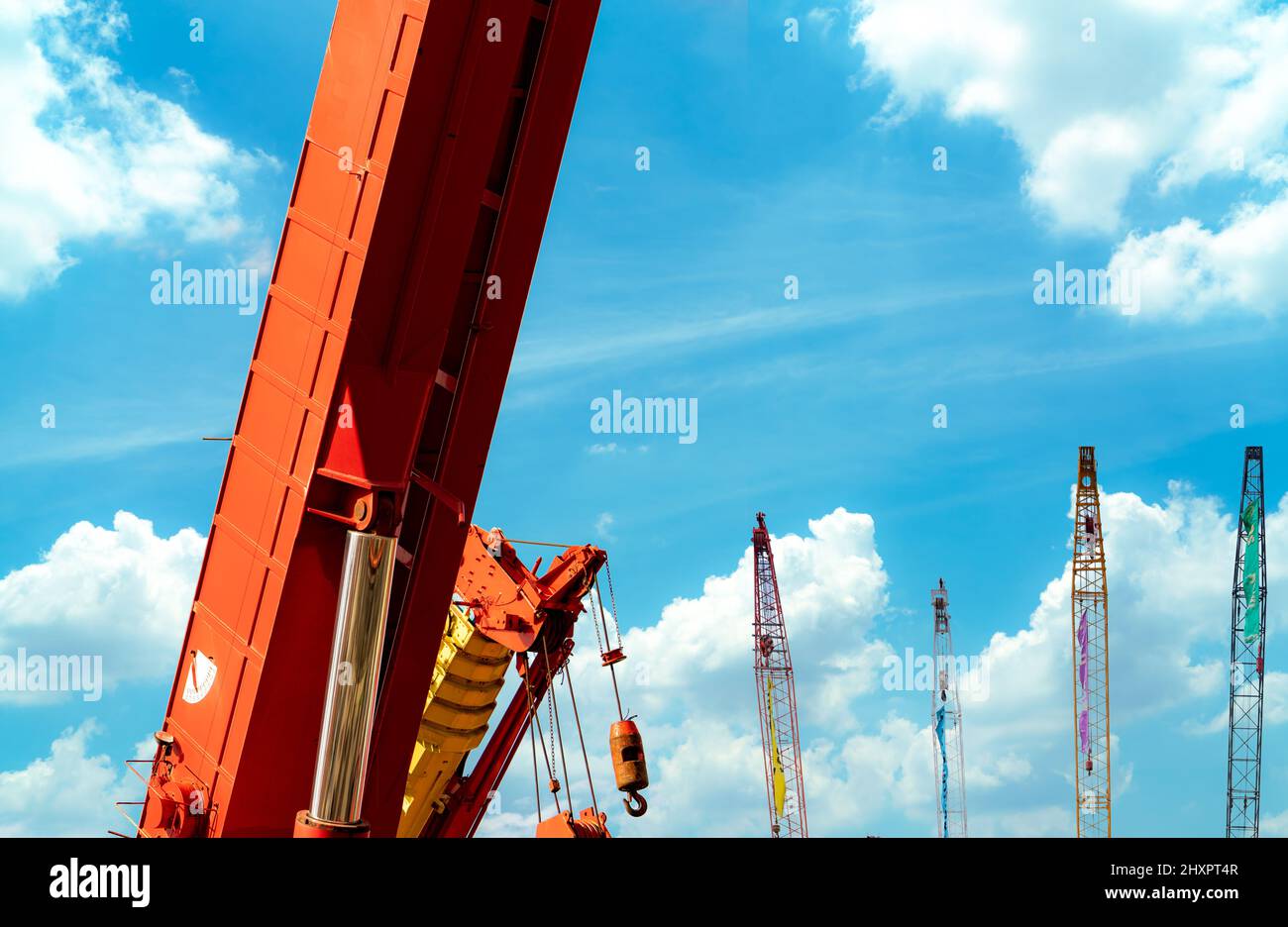 Crawler crane against blue sky and white clouds. Real estate industry