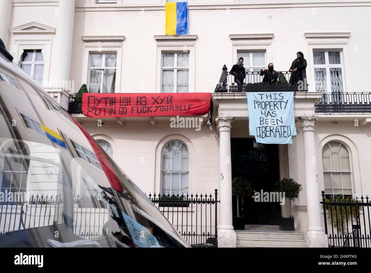 Protesters occupy the property of Russian Oligarch and Putin ally, Oleg Deripaska at 5 Belgrave Square in Knightsbridge, on 14th March 2022, in London, England. The Squatters have hanged the Ukrainian flag from an upper window and show banners saying, 'This property has been liberated' and an anti-Putin slogan. Stock Photo