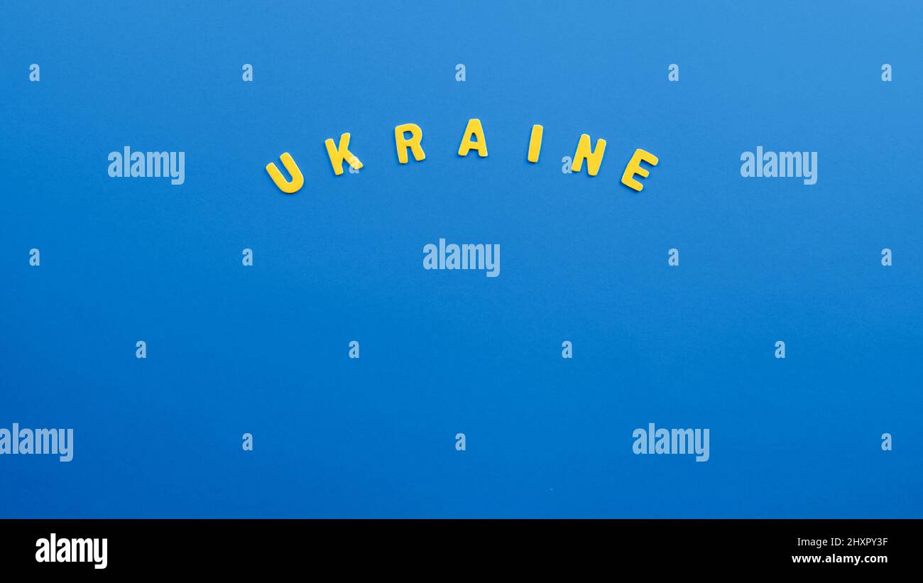 Yellow Ukraine lettering on blue background. Ukraine Conflict Stock Photo