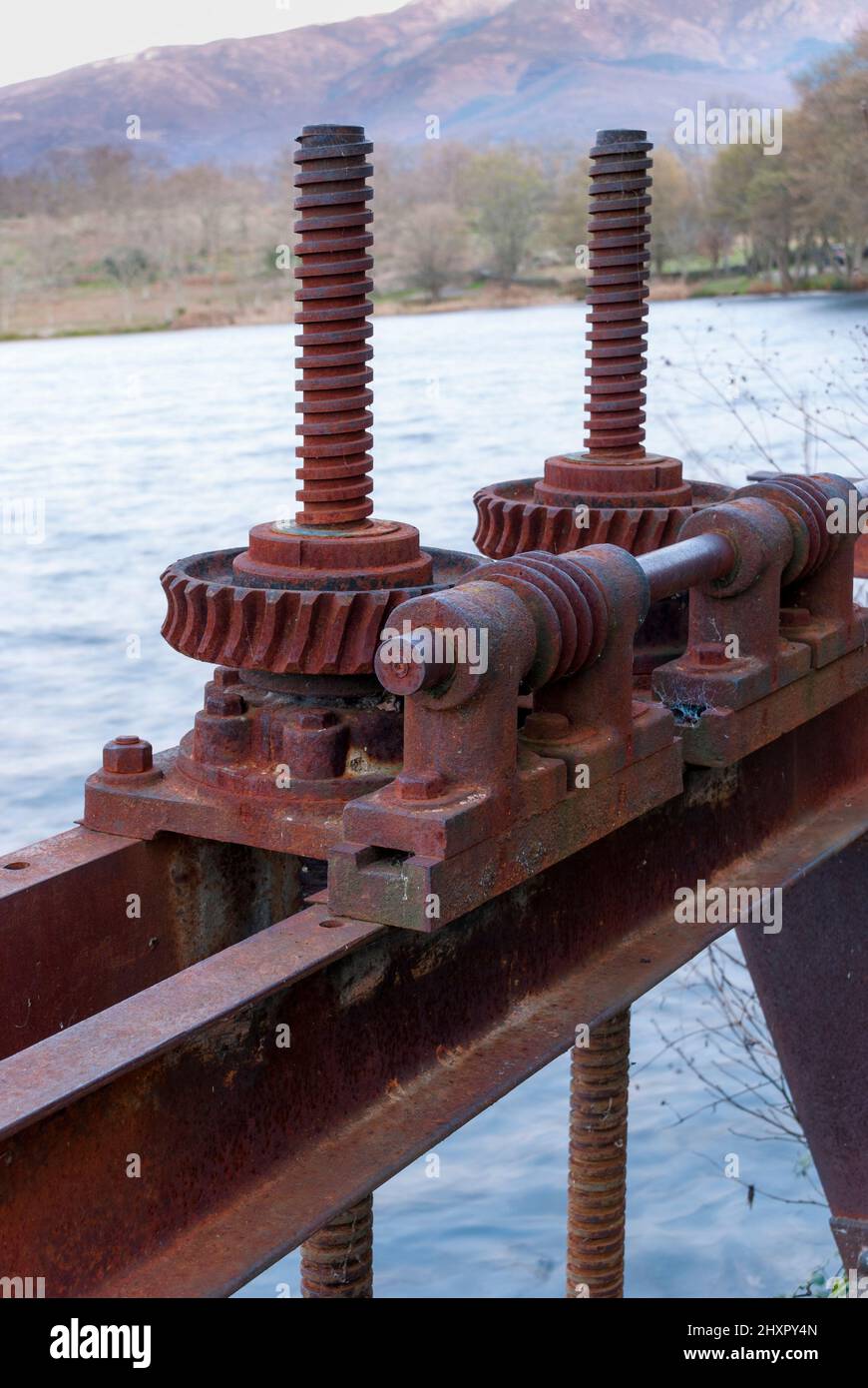 Old rusty red stopcocks to open a water dam gate in the Ambroz Valley Stock Photo