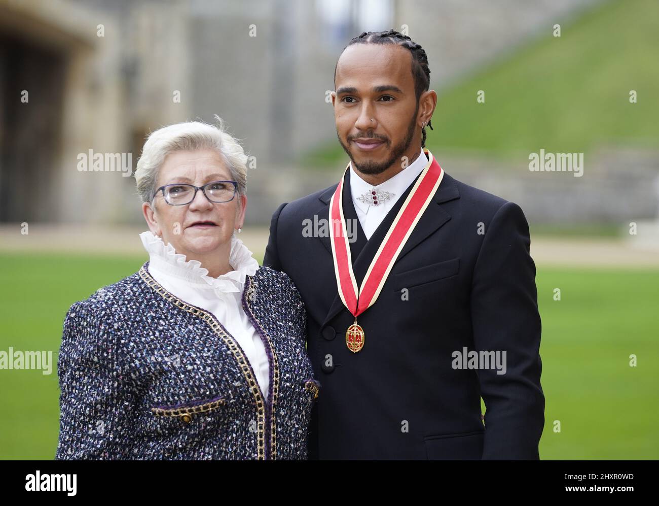 File photo dated 15-12-2021 of Sir Lewis Hamilton with his mother Carmen Lockhart after he was made a Knight Bachelor by the Prince of Wales during a investiture ceremony at Windsor Castle. Hamilton has revealed he is in the process of changing his name. The seven-time world champion says he intends to incorporate his mother's maiden name, Larbalestier, alongside Hamilton. Issue date: Monday March 14, 2022. Stock Photo